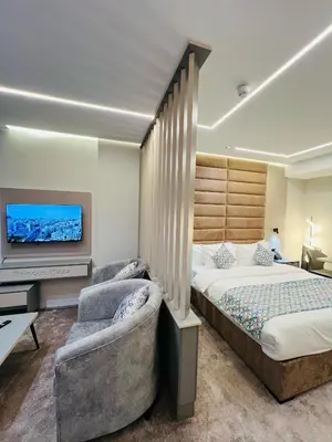 a bedroom with a bed and a flat screen tv at فندق الأمراء بلازا in Ma‘ān