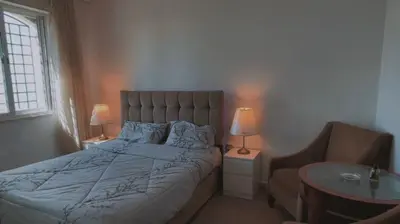 a bedroom with a bed and a chair and a table at شقق ڤيڤا - viva Apartments in Amman