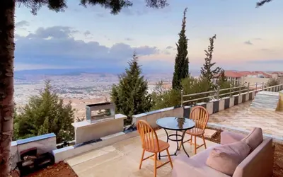a patio with a table and chairs and a view at شقق ڤيڤا - viva Apartments in Amman