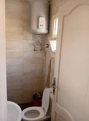 a bathroom with a white toilet and a sink at الجبل الاخضر هاوس in Al ‘Ālūk