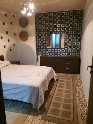 a bedroom with a bed and a mirror on the wall at الجبل الاخضر هاوس in Al ‘Ālūk