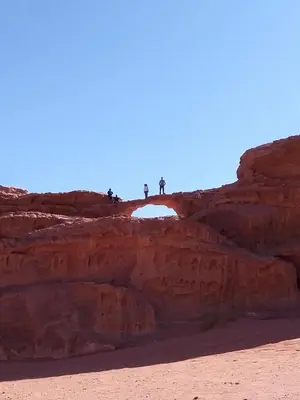people standing on top of a cliff in the desert at Rum bubble camp in Wadi Rum
