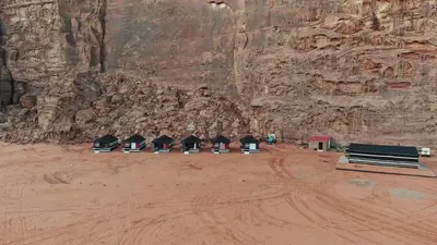a group of benches in front of a rock wall at Rum bubble camp in Wadi Rum