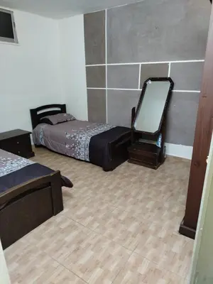 a room with two beds and a mirror in it at شقة الياسمين عمّان الأرضيّة للعائلات in Amman