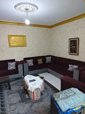 a living room with a couch and a table at شقة الياسمين عمّان الأرضيّة للعائلات in Amman