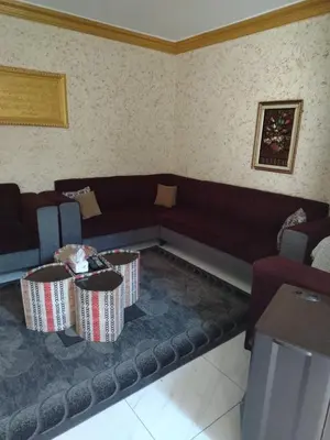 a living room with a couch and two tables at شقة الياسمين عمّان الأرضيّة للعائلات in Amman