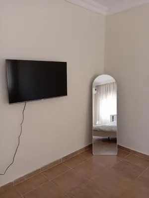 a flat screen tv on a wall with a mirror at Stay with Saja Homey Room Heart of Weibdeh in Jurf ad Darāwīsh