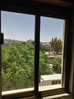 an open window with a view of a city at Stay with Saja Homey Room Heart of Weibdeh in Jurf ad Darāwīsh