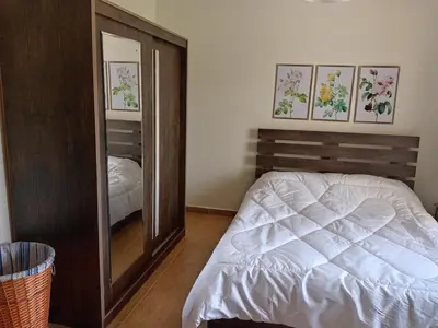 a bedroom with a mirror next to a bed at Stay with Saja Homey Room Heart of Weibdeh in Jurf ad Darāwīsh