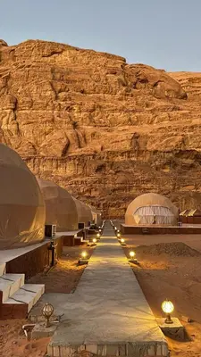 a row of domes with lights in the desert at RUM FLORAA LUXURY CAMp in Wadi Rum