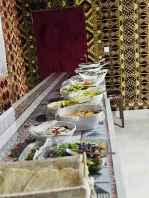 a buffet line of bowls of food on a table at RUM FLORAA LUXURY CAMp in Wadi Rum