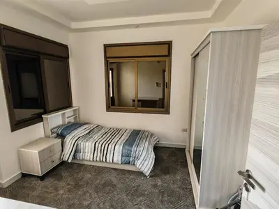 a bedroom with a bed and a mirror on the wall at Furnished apartment - Irbid in Irbid