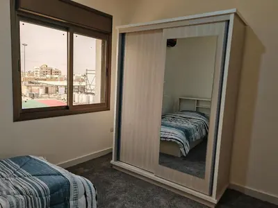 a mirror in a room with a bed and a window at Furnished apartment - Irbid in Irbid