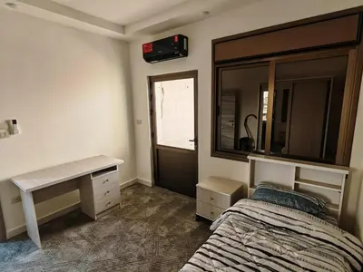 a bedroom with a bed and a desk and a mirror at Furnished apartment - Irbid in Irbid