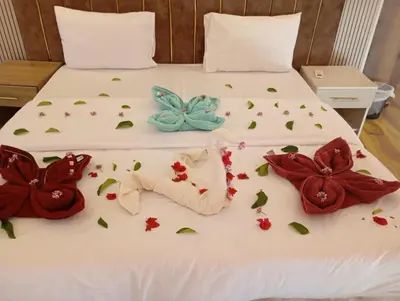 a white bed with flowers and a butterfly on it at Wasan Camp Wadi Rum in Wadi Rum