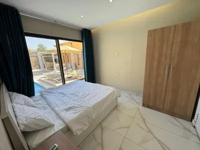 a bedroom with a bed and a large window at Oia chalet in Ash Shāghūr