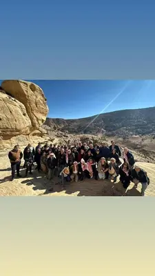 a group of people posing for a picture in the desert at Camping in Dana in At-Tafilah