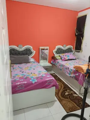 two beds in a room with orange walls at ايدون هاوس in Aydūn