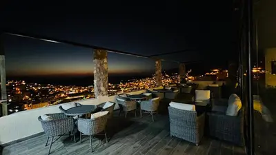 a restaurant with tables and chairs on a balcony at night at Tetra Tree Hotel 1 in Wadi Musa