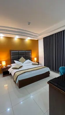 a bedroom with a large bed and a desk at Tetra Tree Hotel 1 in Wadi Musa