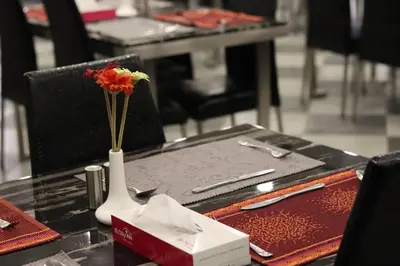 a vase with a flower in it on a table at Easy Inn Hotel Suites in Amman