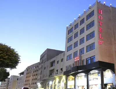 a building with a hotel sign on the side of it at Easy Inn Hotel Suites in Amman