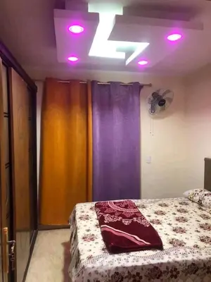 a bedroom with a bed with purple lights on it at الاغوار هاوس in Khirbat ash Shaykh Muḩammad