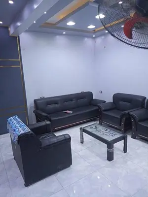 a living room with black couches and a coffee table at الاغوار هاوس in Khirbat ash Shaykh Muḩammad