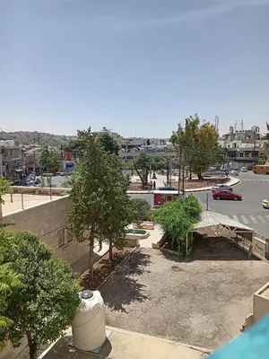 a view of a parking lot with trees and a street at Stay with Saja Room in Weibdeh in Jurf ad Darāwīsh