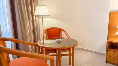 a small table and chair with a cup on it at Aqaba Gulf Hotel By FHM in Aqaba