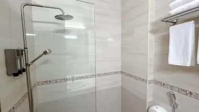 a shower with a glass door in a bathroom at Aqaba Gulf Hotel By FHM in Aqaba
