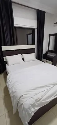 a large white bed in a room with a window at شقق الجبيهة العائلية in Amman