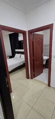 a room with a bedroom with a bed and a mirror at شقق الجبيهة العائلية in Amman