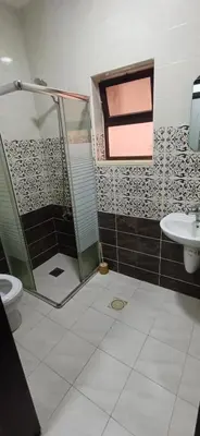 a bathroom with a shower and a toilet and a sink at شقق الجبيهة العائلية in Amman