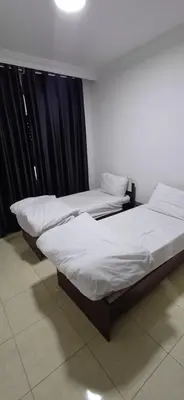 two twin beds in a room with black curtains at شقق الجبيهة العائلية in Amman