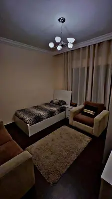a bedroom with a bed and a chair and a couch at شقه مفروشه in Jurf ad Darāwīsh