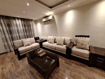 a living room with two couches and a coffee table at شقه مفروشه in Jurf ad Darāwīsh