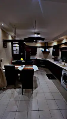 a large kitchen with a table and chairs in it at شقه مفروشه in Jurf ad Darāwīsh