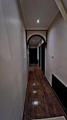 an empty hallway with a wooden floor and an archway at شقه مفروشه in Jurf ad Darāwīsh
