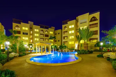 a swimming pool in front of a building at night at Der Ghbar Luxe in Amman