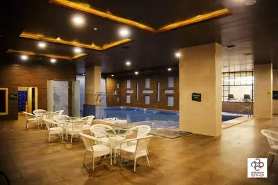 a room with tables and chairs and a swimming pool at Der Ghbar Luxe in Amman