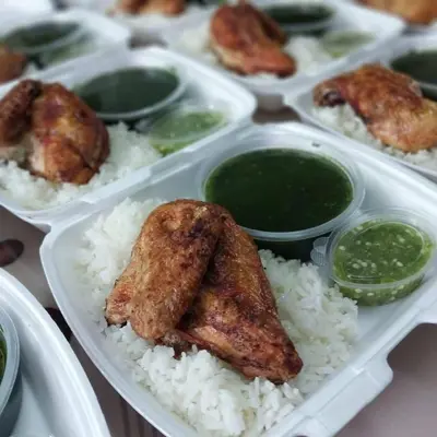 a styrofoam container with rice and chicken wings and sauce at الازرق فارم in Al Azraq ash Shamālī