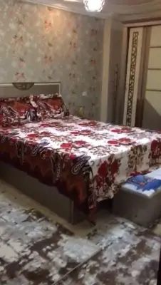 a bedroom with a bed with a red and white blanket at الازرق فارم in Al Azraq ash Shamālī