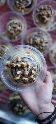 a hand holding a cupcake with nuts on it at الازرق فارم in Al Azraq ash Shamālī