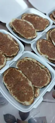 a bunch of pancakes in plastic containers on a table at الصدقه ان in Aş Şadaqah