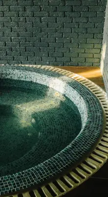 a large pool of water next to a brick wall at Al Bader Resort in Jurf ad Darāwīsh
