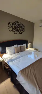a large white bed in a room with at Layaali Amman Hotel Airport Pickup in Amman