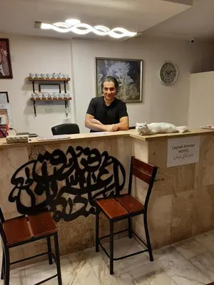 a man sitting at a counter with two chairs at Layaali Amman Hotel Airport Pickup in Amman