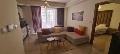 a living room with a couch with colorful pillows at فورتاليزا للإسكان in Jurf ad Darāwīsh