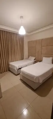 a bedroom with two beds and a light fixture at فورتاليزا للإسكان in Jurf ad Darāwīsh
